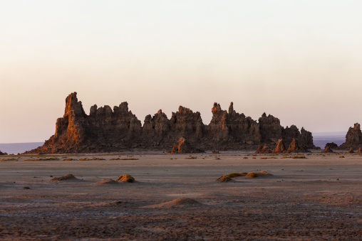 Limestone chimney rock formations glow at sunset over the salt flat, Afar depression, Lake Abbe, Djibouti