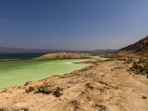 A rocky headland separates turquoise lagoons in the volcanic crater landscape, Dikhil Region, Lake Assal, Djibouti