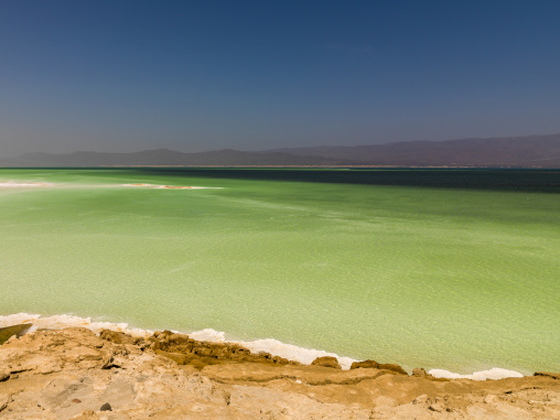 Turquoise water gradually deepens to dark blue beneath a hazy mountain horizon, Dikhil Region, Lake Assal, Djibouti