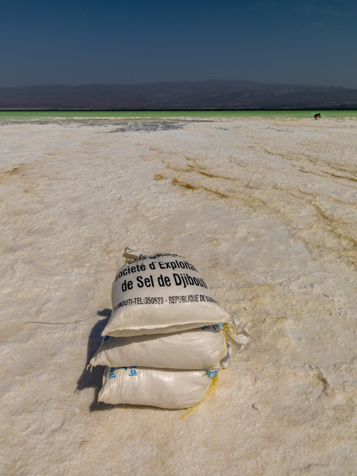 Sacks of harvested salt rest on the white crust of Lake Assal, Dikhil Region, Lake Assal, Djibouti