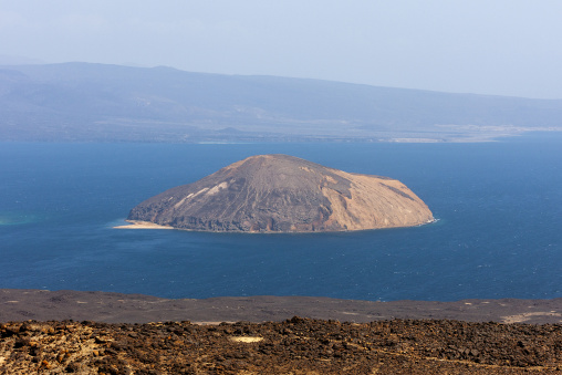 A cone-shaped volcanic island sits alone in the blue waters of the Devil's Cauldron, Tadjourah Region, Goubet Al-kharab, Djibouti