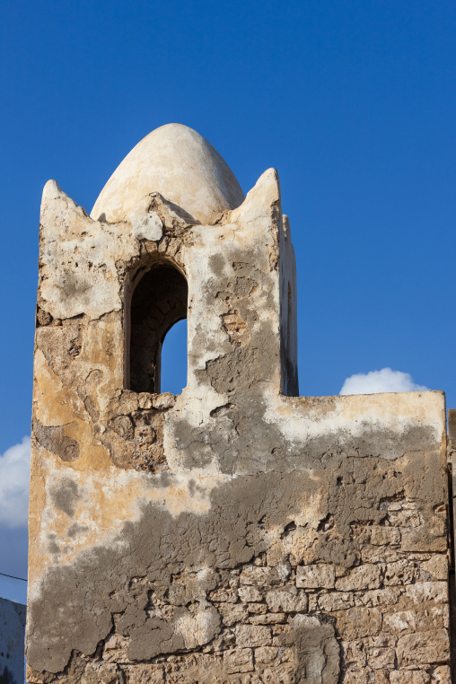 A weathered stone minaret with a domed roof rises against a clear blue sky, Tadjourah Region, Tadjoura, Djibouti
