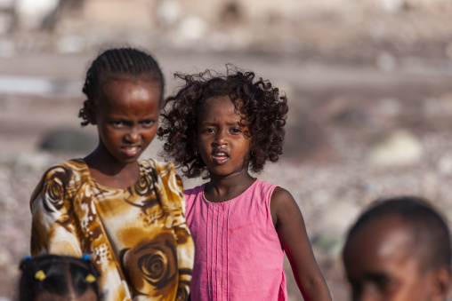 Two young Afar girls pose closely together outdoors in soft afternoon light, Tadjourah Region, Tadjoura, Djibouti