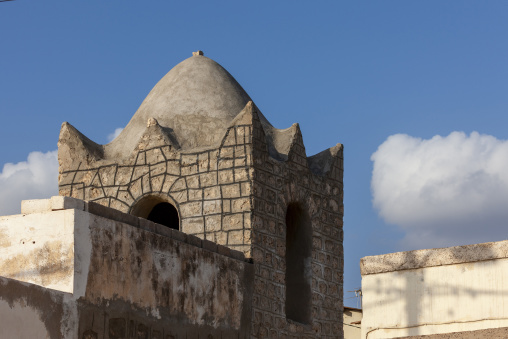 An ornately carved stone minaret with a rounded dome overlooks the old town rooftops, Tadjourah Region, Tadjoura, Djibouti