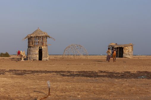 Traditional straw huts stand on a sandy beach near the sea, Obock Region, Gorodia, Djibouti