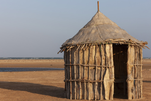 A woven straw hut stands near the shoreline, Obock Region, Gorodia, Djibouti