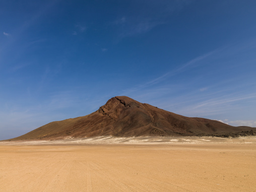 Isolated volcanic peak rises above a desert plain, Obock Region, Khor angar, Djibouti