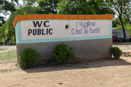 A painted public toilet sign reads a hygiene awareness message in French, Bafing, Gboni, Ivory Coast