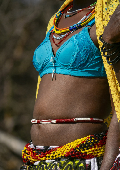 Close-up of a Mudimba tribe woman's torso adorned with beaded necklaces and a waist belt over traditional clothing, Cunene Province, Cahama, Angola