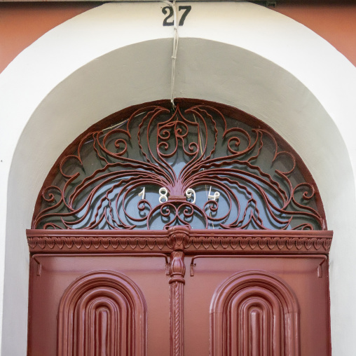 Ornate wrought-iron transom with the date 1894 decorates the arched doorway of a colonial house, Luanda Province, Luanda, Angola