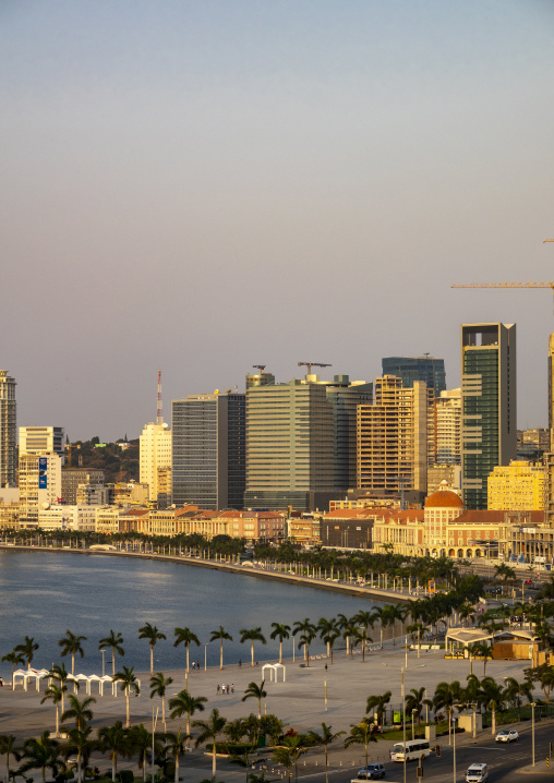 Hazy sky stretches above the skyline and palm-lined waterfront of Luanda Bay, Luanda Province, Luanda, Angola