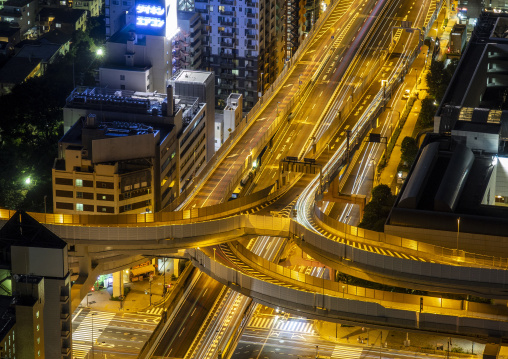 Aerial night view of a curving highway interchange with light tr
