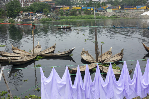 Traditional wooden rowboats moored on the river with laundry dry
