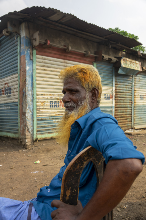 Portrait of an elderly man with a henna-dyed orange beard sittin