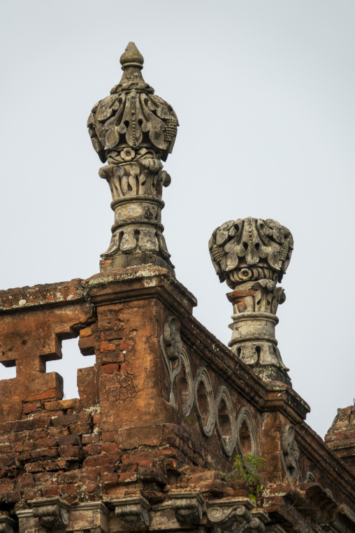 Ornate stone finials crowning the ruined facade of a zamindar ma