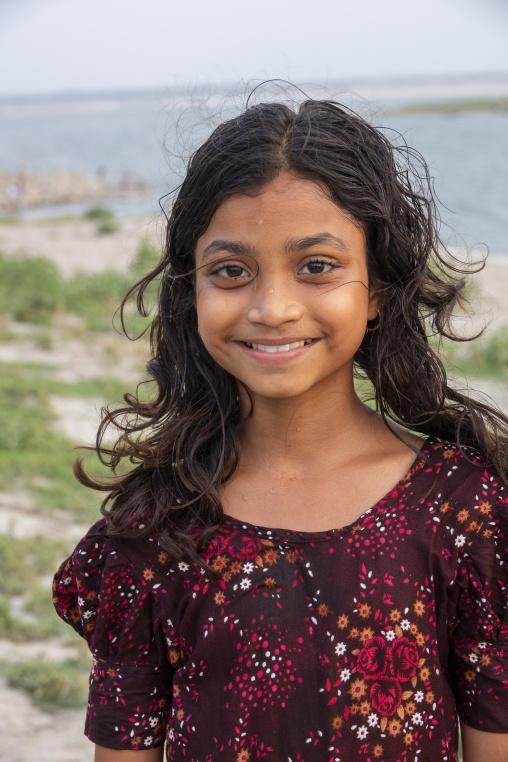 Portrait of a smiling girl with wet hair by the riverside, Dhaka