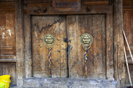 Weathered wooden door of the monastic college kitchen stands at Bongya monastery, Qinghai Province, Mosele, China