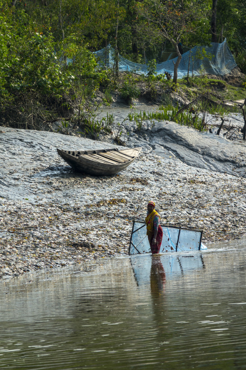 Bangladeshi woman fishing shrimps in the river, Khulna Division, Mongla, Bangladesh