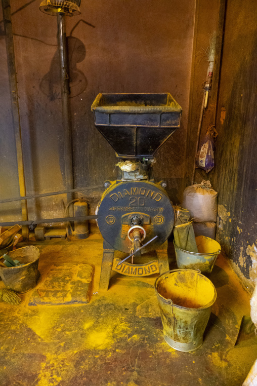 Old turmeric grinding machine covered in yellow powder, Dhaka Di