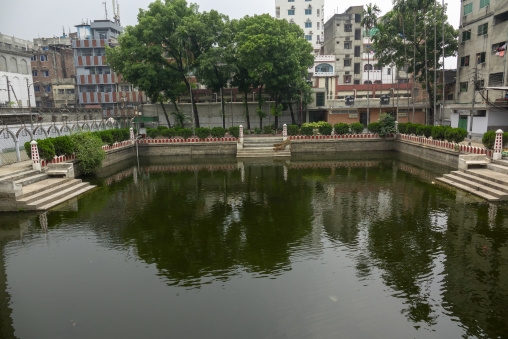 Reflecting pond bordered by red and white pillars in the Hussain