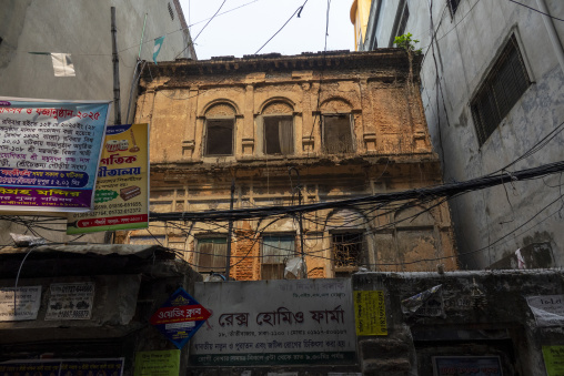 Crumbling colonial-era brick building with arched windows above