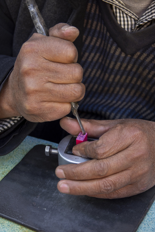 Craftsman carves a traditional Chinese stamp with a hand tool, Gansu Province, Linxia, China