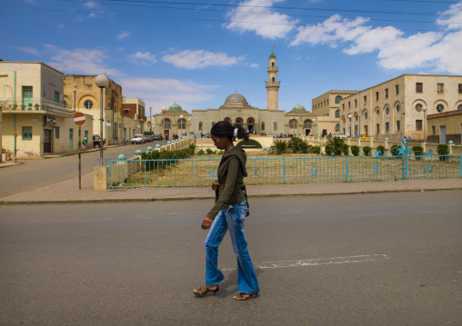 Eritrean woman passing in front of grand mosque Kulafa al Rashidin, Central Region, Asmara, Eritrea
