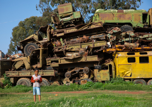 Eritrean boy in the military tank graveyard, Central region, Asmara, Eritrea