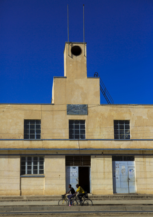 Eritrean men passing in front of an old colonial italian factory, Debub, Dekemhare, Eritrea