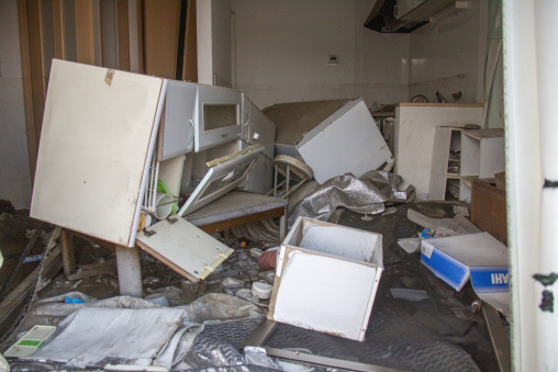 Debris and overturned furniture inside an abandoned house in the