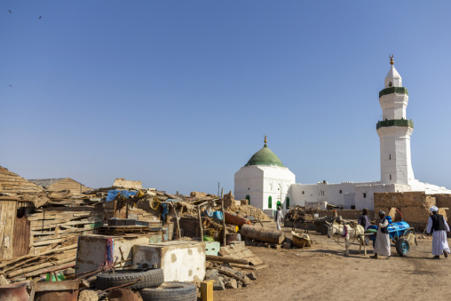 A domed mosque with a minaret rises above ruined buildings and a donkey cart in the old town, Red Sea State, Suakin, Sudan