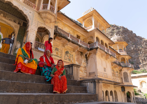 Rajasthani women sit on Galtaji temple stairs, Rajasthan, Jaipur, India