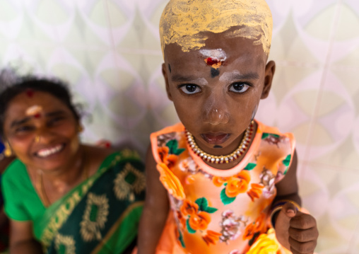 Indian girl with sandalwood paste on shaved head, Tamil Nadu, Karaikudi, India