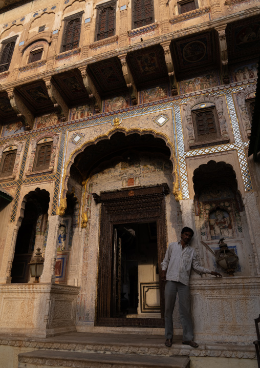 Indian man standing at Seth Arjun Das Goenka Haveli entrance, Rajasthan, Dundlod, India