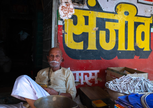 Indian man sit in front of his shop, Rajasthan, Ramgarh Shekhawati, India