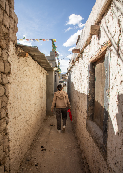 Woman in a narrow street of Sonamling Tibetan settlement, Ladakh, Leh, India