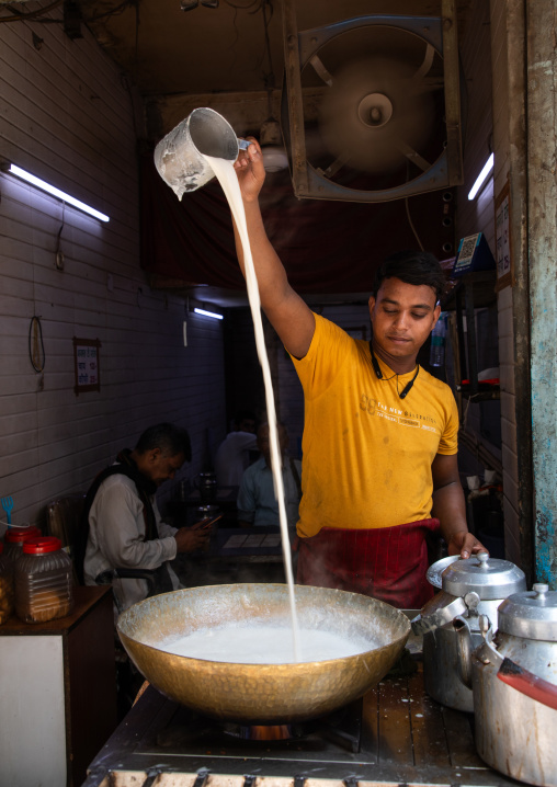 Indian man pouring hot milk tea in old Delhi, Delhi, New Delhi, India