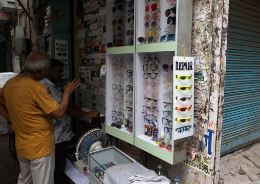 Indian man choosing eyeglasses in a optics, Delhi, New Delhi, India