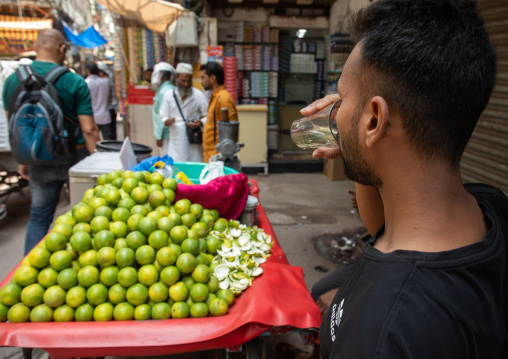 Indian man drinking orange juice in old Delhi, Delhi, New Delhi, India