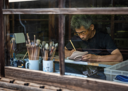 Artisan working in Genemongama porcelain atelier, Kyushu region, Arita, Japan