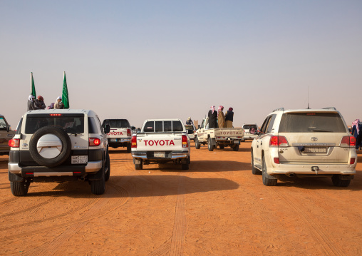 Saudi men following camels with their cars during King Abdul Aziz Camel Festival, Riyadh Province, Rimah, Saudi Arabia
