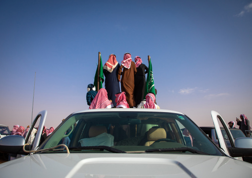 Saudi men following camels with their cars during King Abdul Aziz Camel Festival, Riyadh Province, Rimah, Saudi Arabia