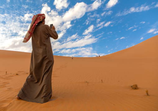 Saudi man taking picture of a Rub al Khali dune, Najran Province, Thar, Saudi Arabia
