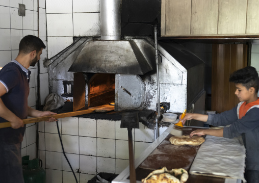 Man putting bread in an oven in a bakery, Mount Lebanon Governorate, Sawfar, Lebanon