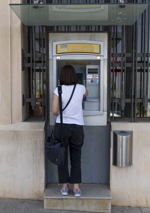 Lebanese woman taking cash in an ATM machine, Baalbek-Hermel Governorate, Baalbek, Lebanon