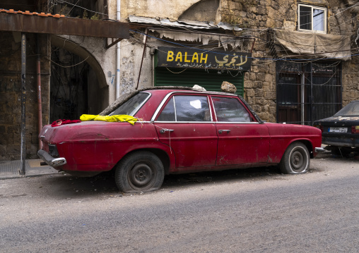 Abandoned red car in the street, North Governorate, Tripoli, Lebanon