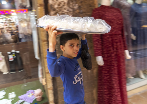 Young syrian boy carrying food on his head in the souk, North Governorate, Tripoli, Lebanon