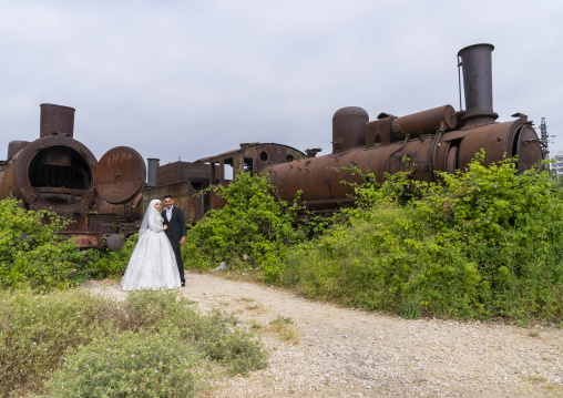 Newly wedded couple in front of Old locomotive from Beirut–Damascus line, North Governorate, Tripoli, Lebanon