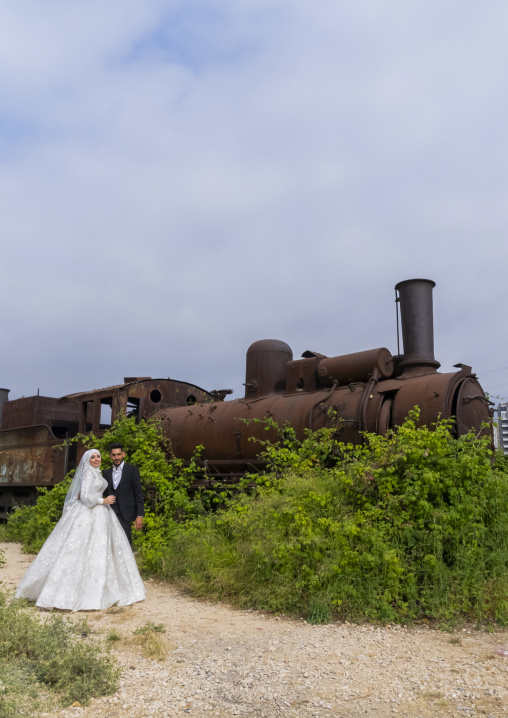 Newly wedded couple in front of Old locomotive from Beirut–Damascus line, North Governorate, Tripoli, Lebanon