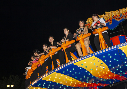 North Korean people in a fairground attraction at Kaeson youth park, DGC, Pyongyang, North Korea